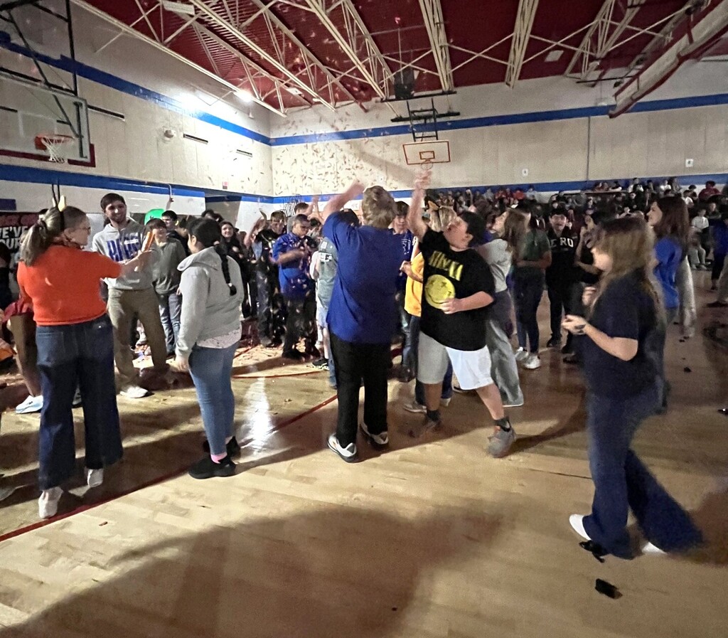 Photo of students and staff participating in house reveal pep rally.