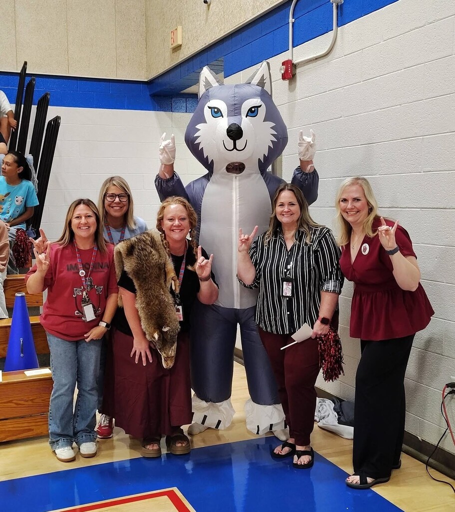 Photo of students and staff participating in house reveal pep rally.