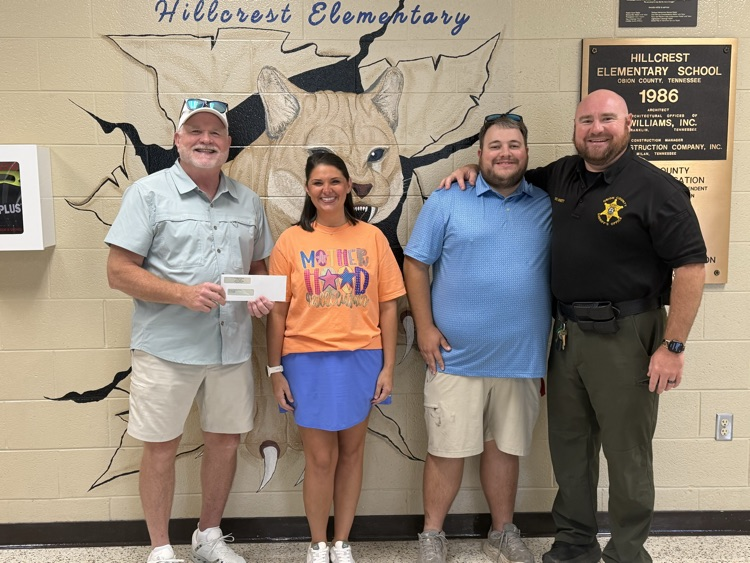 picture of three Troy First Baptist members presenting a donation check to Hillcrest’s SRO Officer Arnett