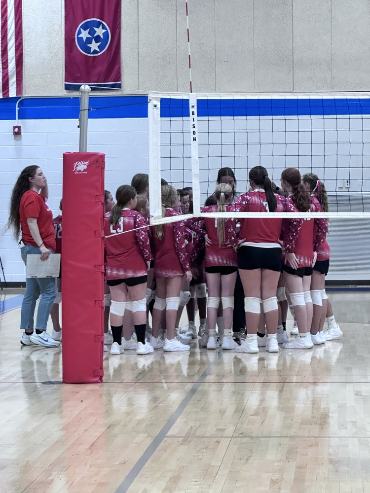 OCMS volleyball players in a huddle