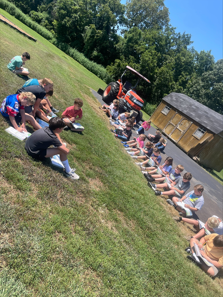 Students are outside on school grounds making observes of the living and nonliving organisms.