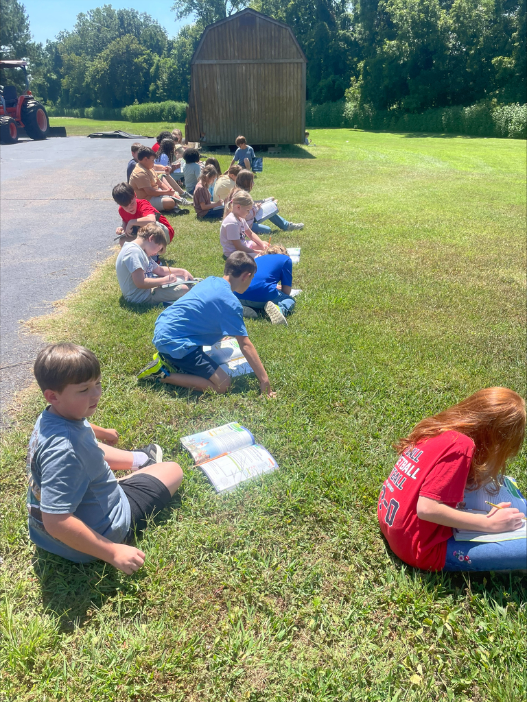 Students are outside on school grounds making observes of the living and nonliving organisms. 