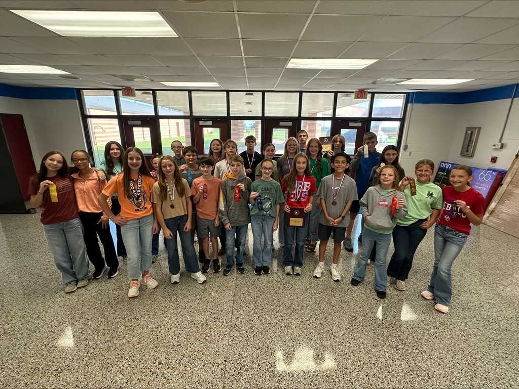 OCMS Cross Country Team gathered in school lobby to show their medals, plaques, and ribbons won at their most recent meet.