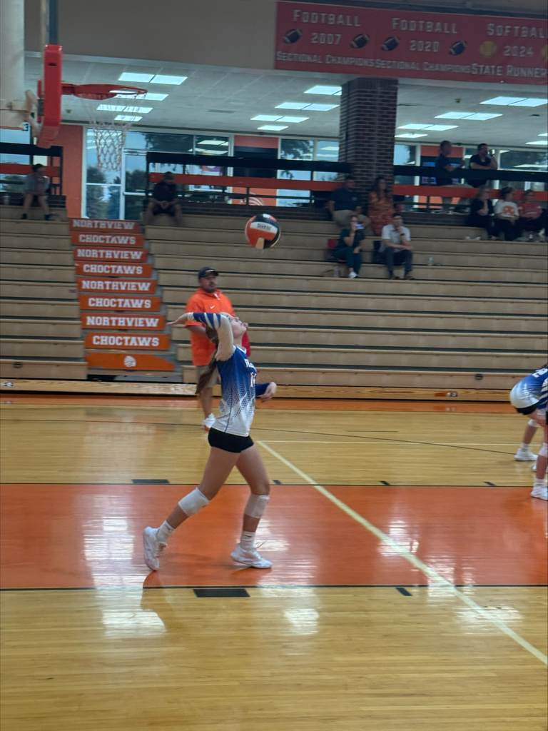 Obion County Middle School volleyball player serves the ball during volleyball game.