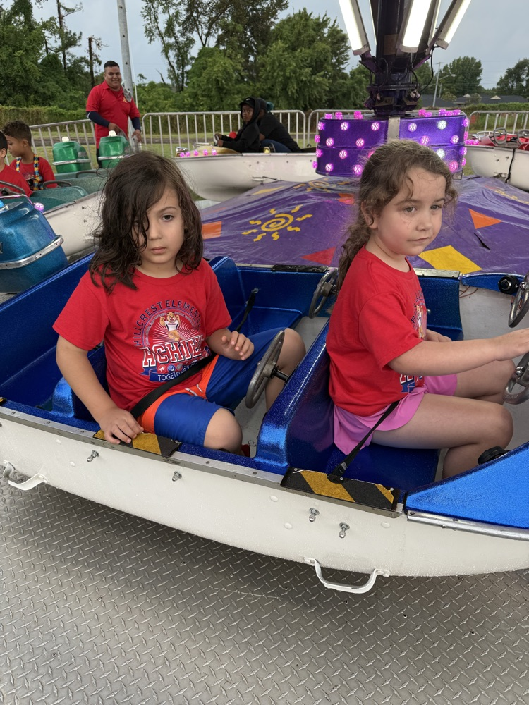 Students from Mrs. Alexis’s CDC class smiling while riding the carousel at the fair,