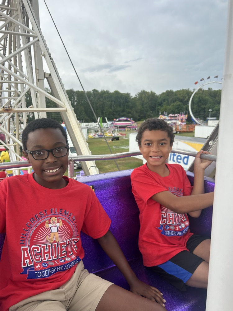 Students from Mrs. Alexis’s CDC class smiling while riding the carousel at the fair,