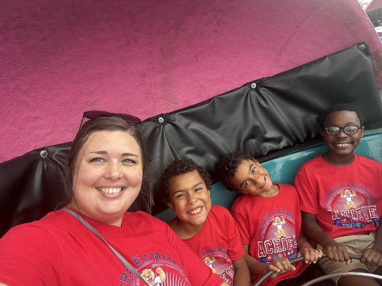 Students from Mrs. Alexis’s CDC class smiling while riding the carousel at the fair,