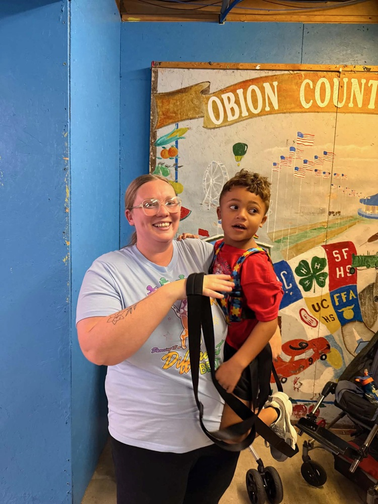 Students from Mrs. Alexis’s CDC class smiling while riding the carousel at the fair,