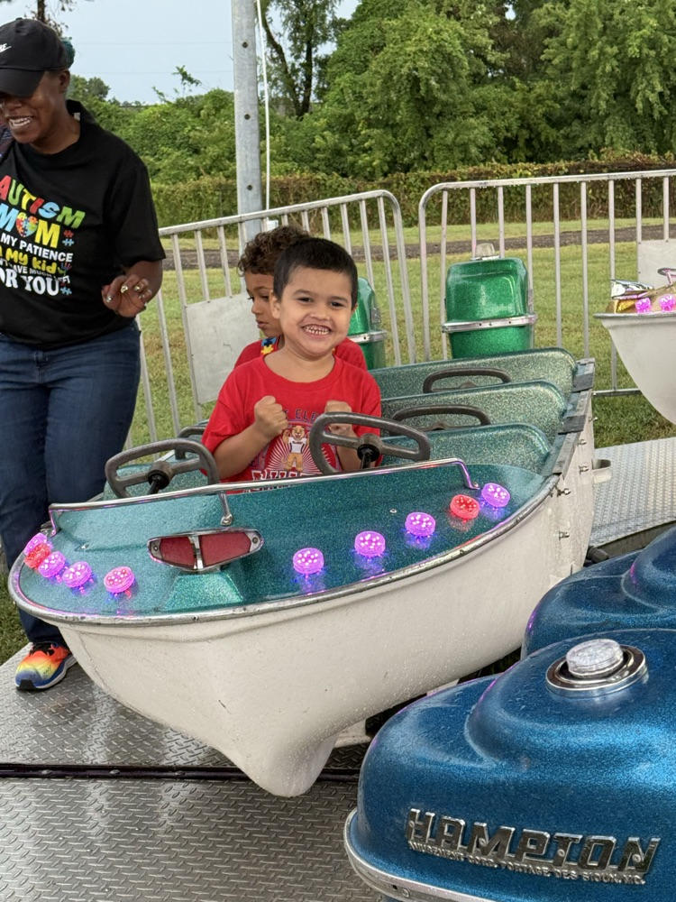 Students from Mrs. Alexis’s CDC class smiling while riding the carousel at the fair,