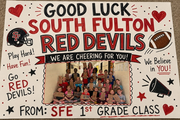 students pictured with good luck art for football team