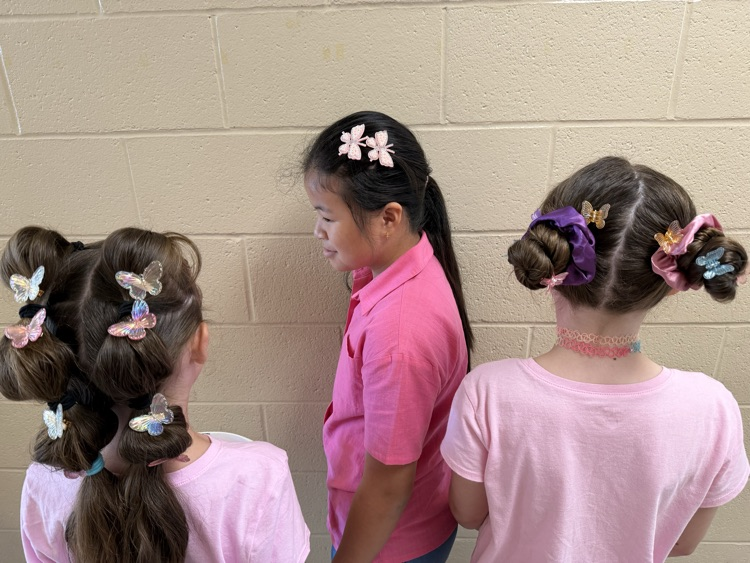 students showing off the butterfly clips in their hair 