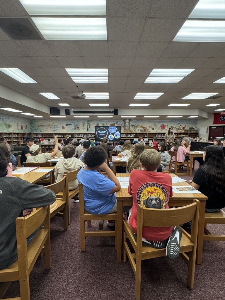 Image of students raising their hands to answer a question.