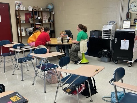 Students sit together at a classroom table, working as a team to complete the September 11 learning activity.