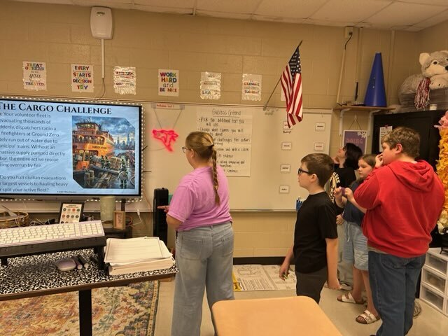A group of students reads the “Cargo Challenge” scenario and discusses how they would respond.