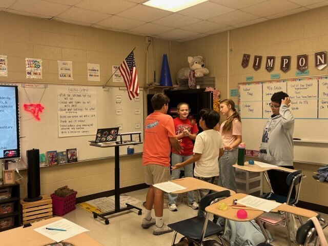 A group of students discusses their assigned scenario while practicing communication and problem-solving skills.