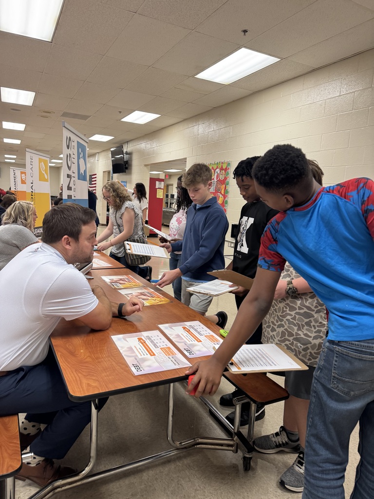 Students participate in South Fulton Middle School’s Financial Fair, reviewing financial information and making budgeting decisions at a station with adult facilitators. The hands-on activity helps students practice managing expenses and making informed financial choices.