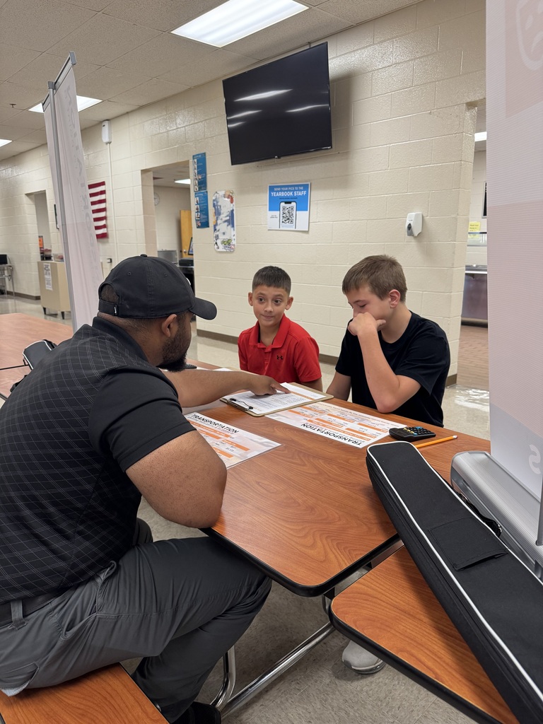 wo South Fulton Middle School students work with an adult facilitator during the Financial Fair, reviewing financial information and making budgeting decisions at a transportation station. A calculator and budgeting worksheets are on the table as students work through their assigned financial scenarios.