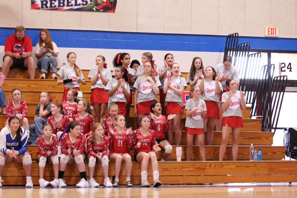 OCMS Cheerleaders and JV Volleyball players cheer in the stands during volleyball game.