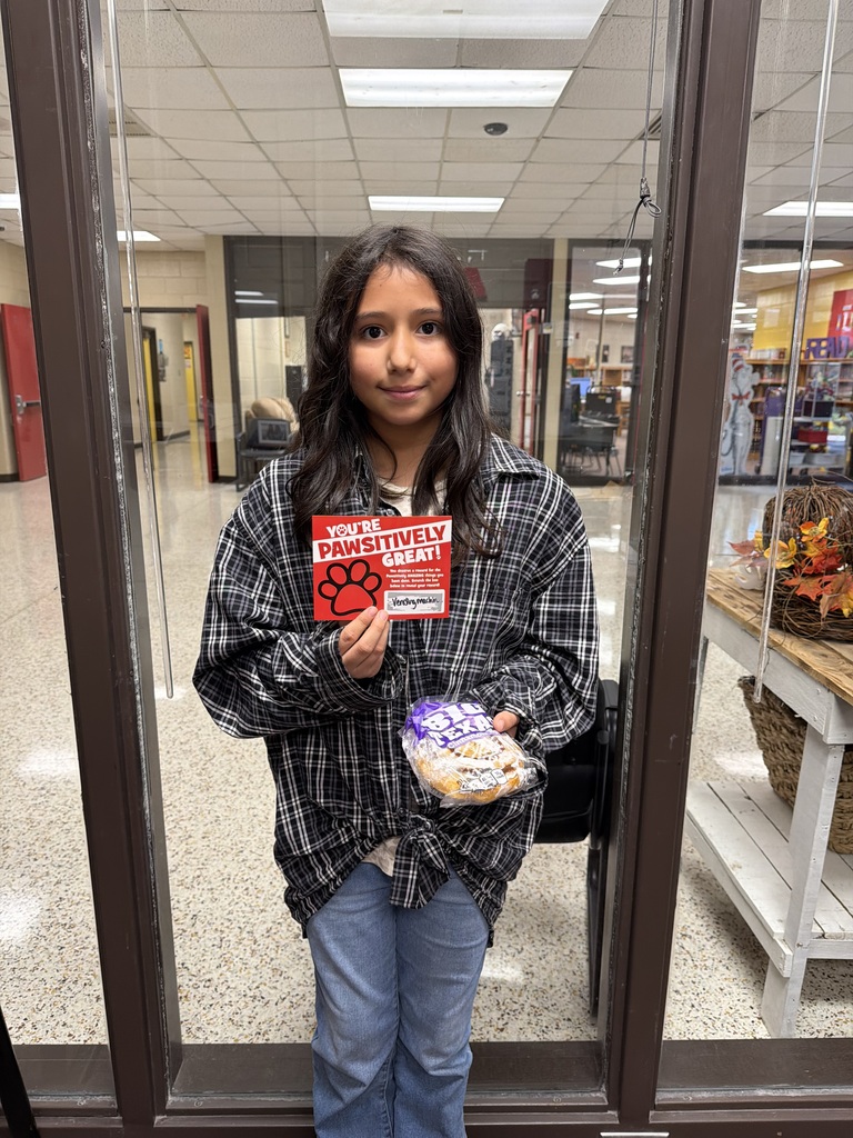 student holding card and honeybun from vending machine 