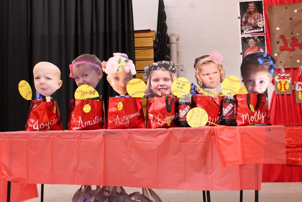 Red gift bags with baby pictures representing the 8th Grade softball players.
