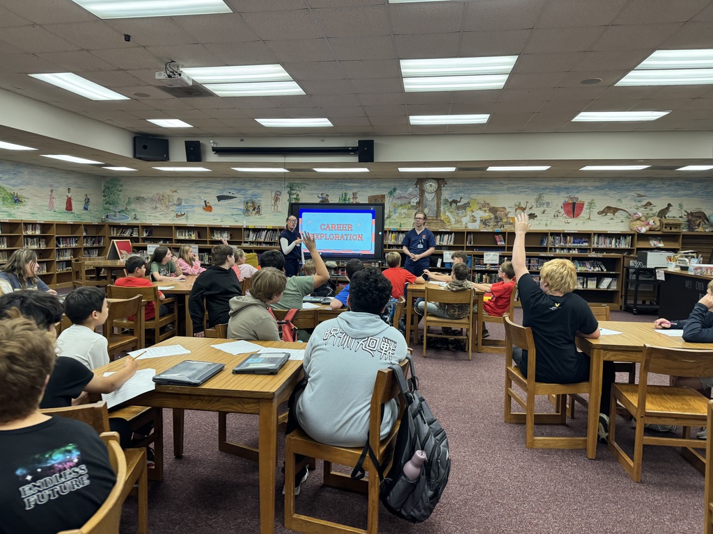 OCMS students participate in a career exploration presentation led by UTM nursing students, with several students raising their hands to answer questions.