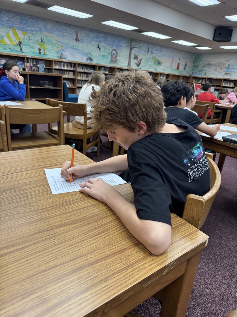 An OCMS student completes a worksheet during a career presentation by UTM nursing students in the school library.