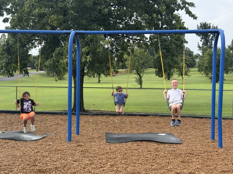 students swinging on playground 