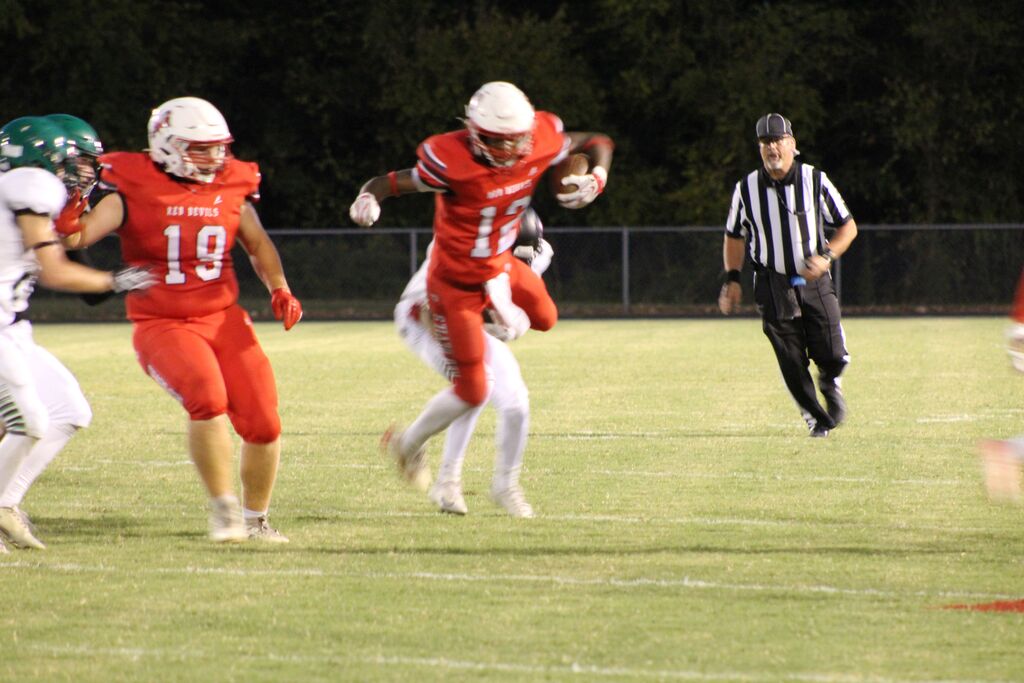A South Fulton football player runs the ball and is stopped by a Ballard County player.