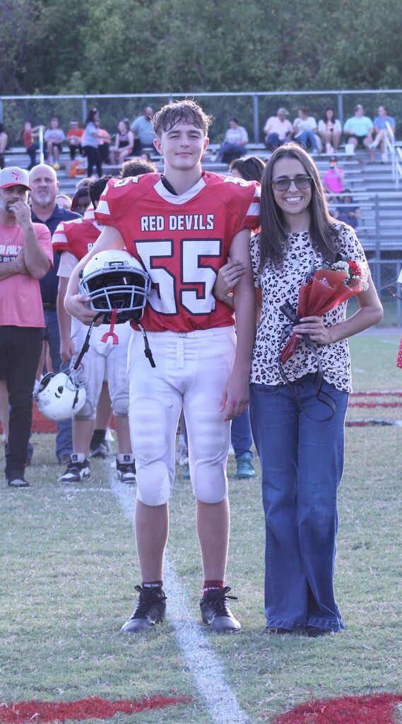 A SFMS football player smiles with his parents.