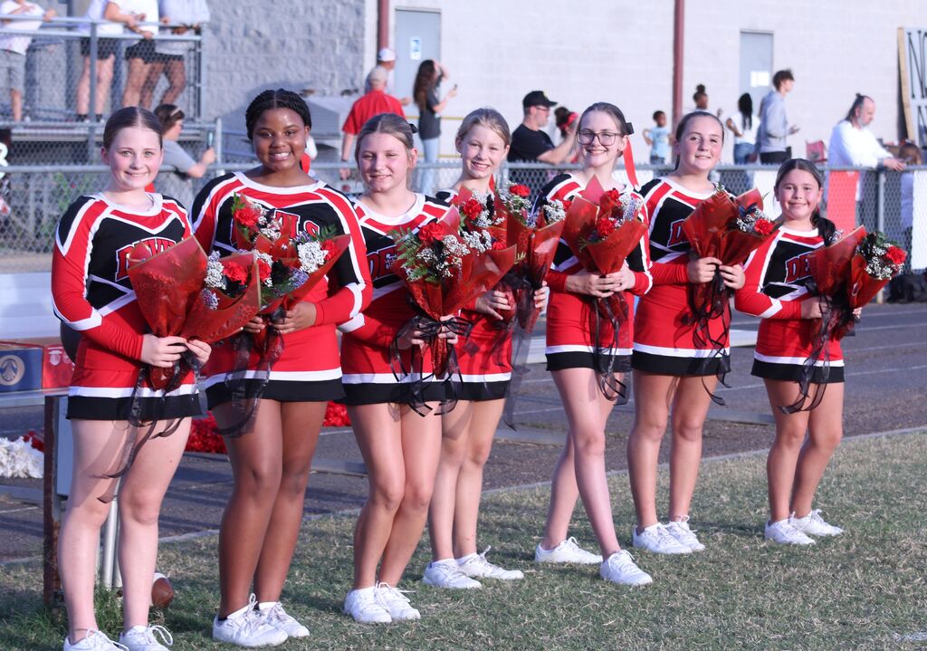 South Fulton Middle School cheerleaders smile while holding flowers.
