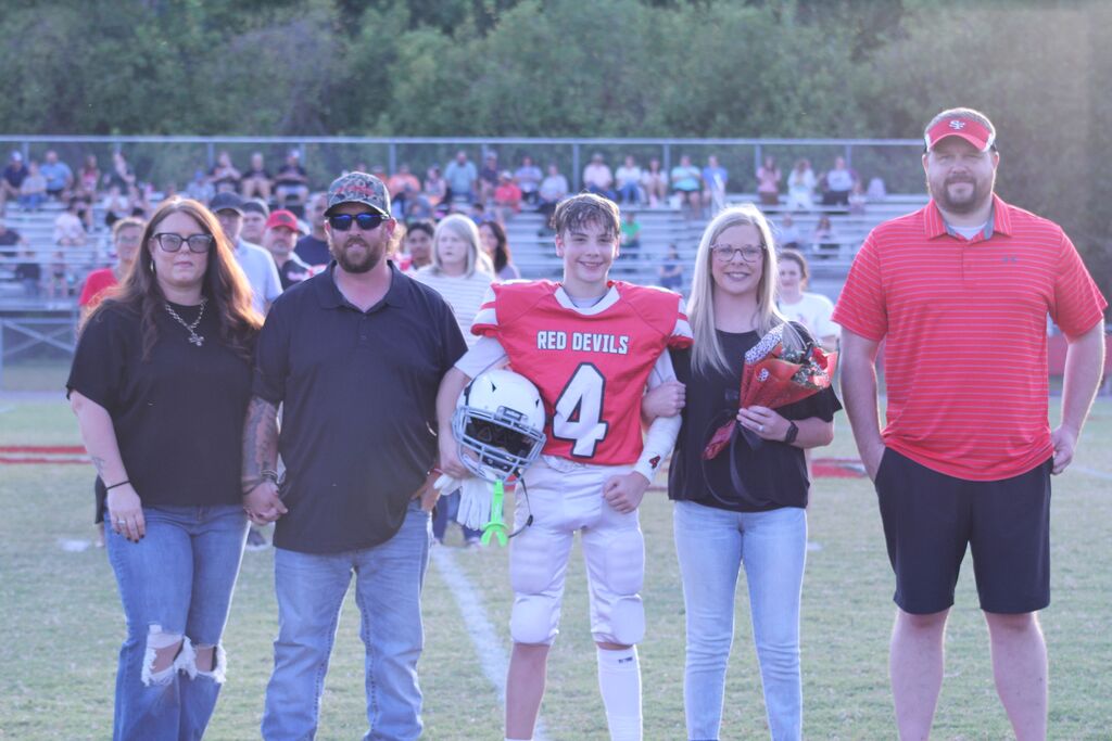 A SFMS football player smiles with his parents.