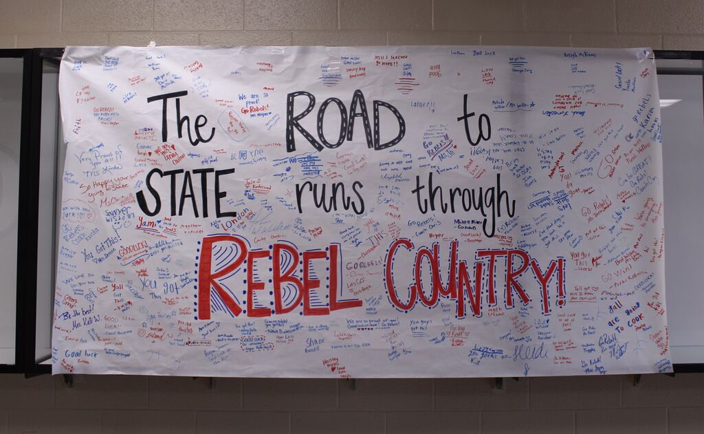 Sign reading "The Road to STATE runs through Rebel Country" and is signed by student body and staff of OCMS.