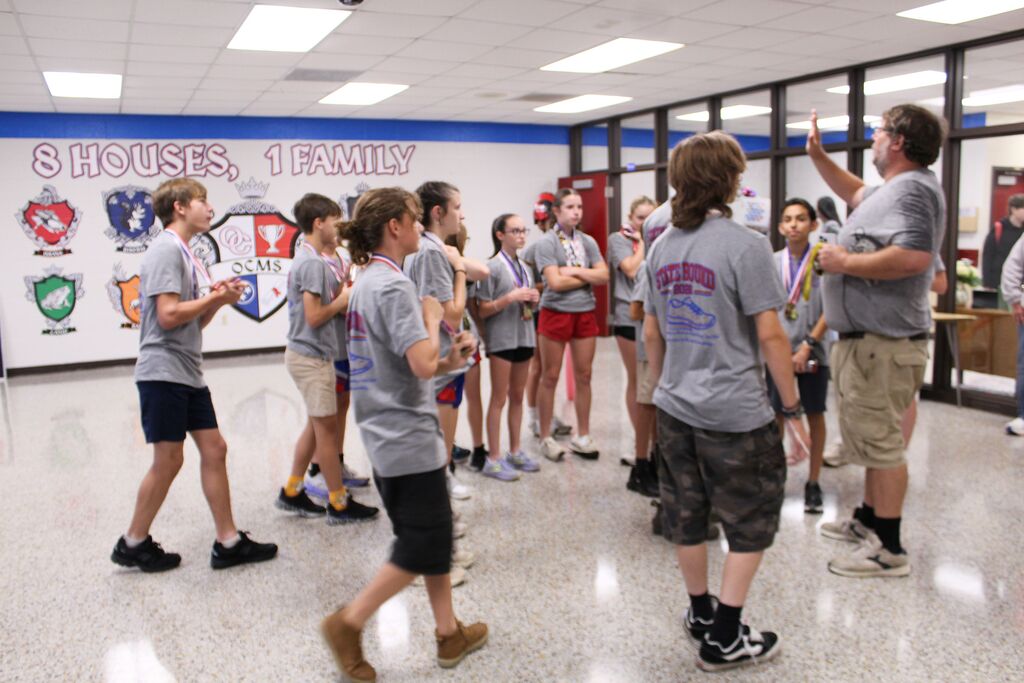 Jaosn Pate, OCMS Cross Country coach, speaks to the group of runners before they run the halls.