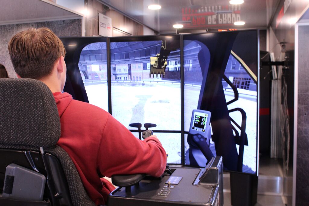An OCCHS student drives a bulldozer simulator on the Be Pro, Be Proud truck.