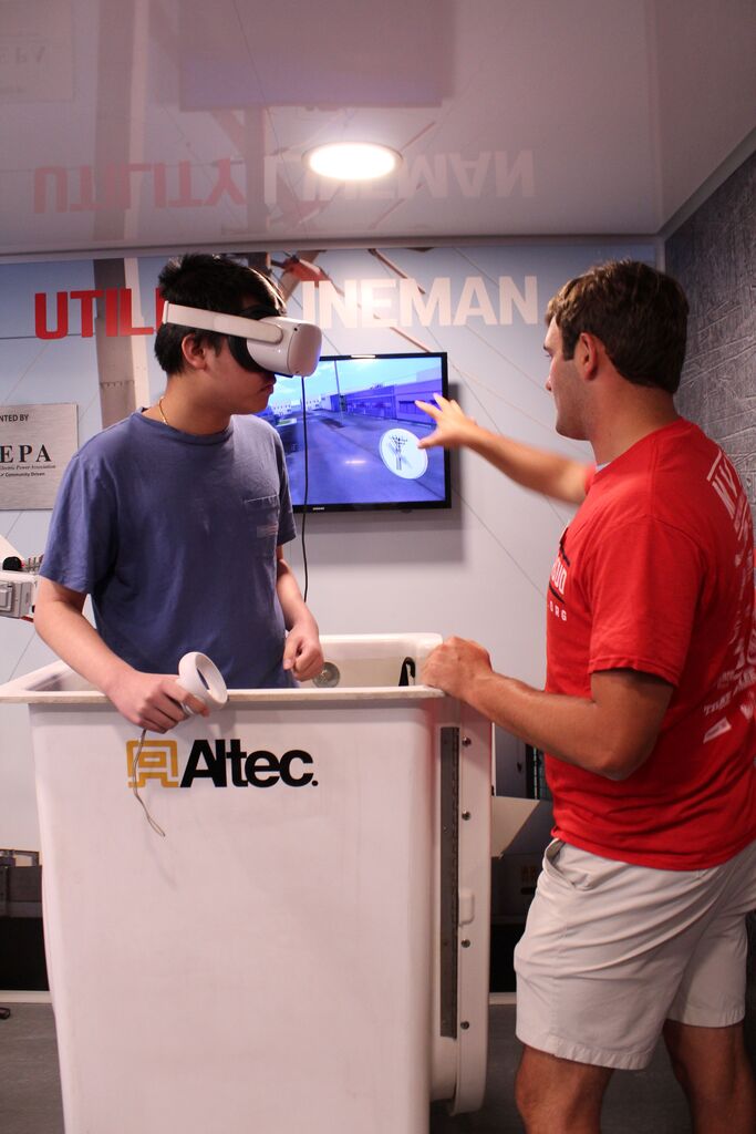 Two OCCHS students use the lineman simulator on the Be Pro, Be Proud truck.