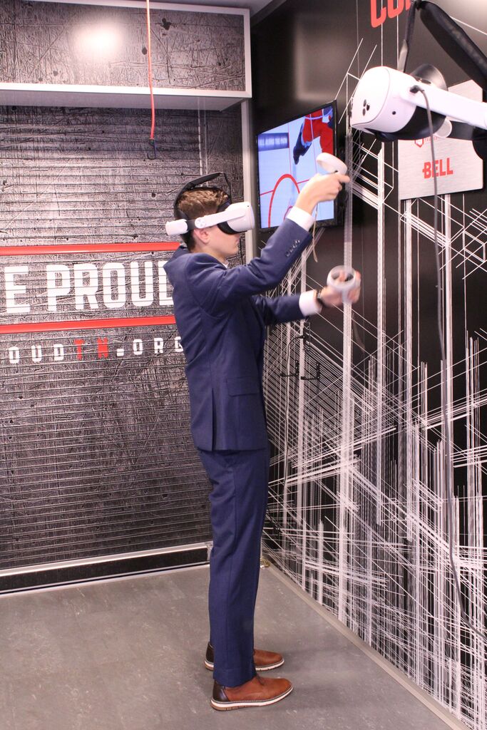 A student wearing a VR headset tries the plumbing simulator on the Be Pro, Be Proud truck.