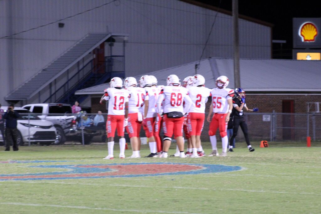South Fulton Red Devils football players gather in a huddle during football game.