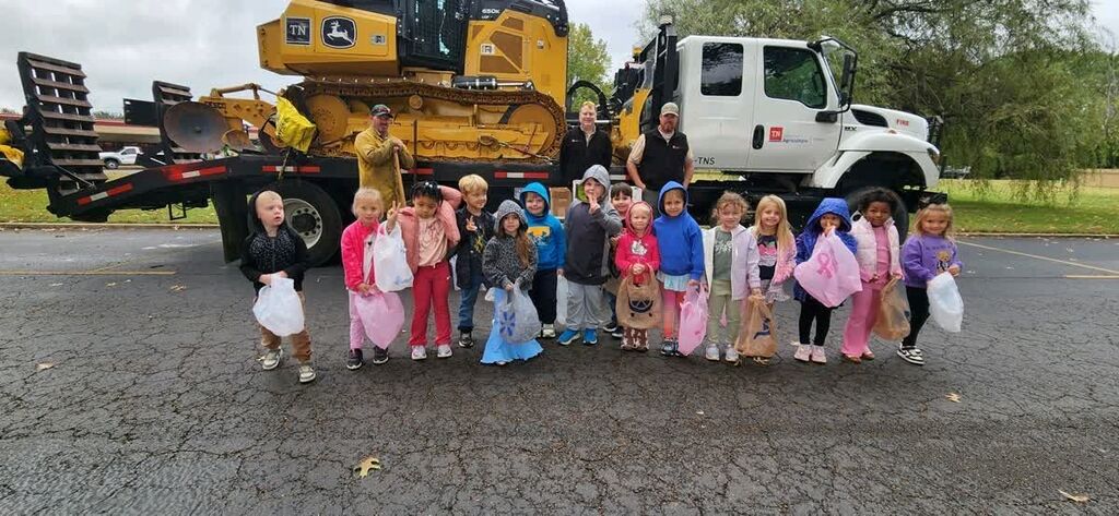 A group of Hillcrest students smile in front of a large truck at Careers on Wheels.