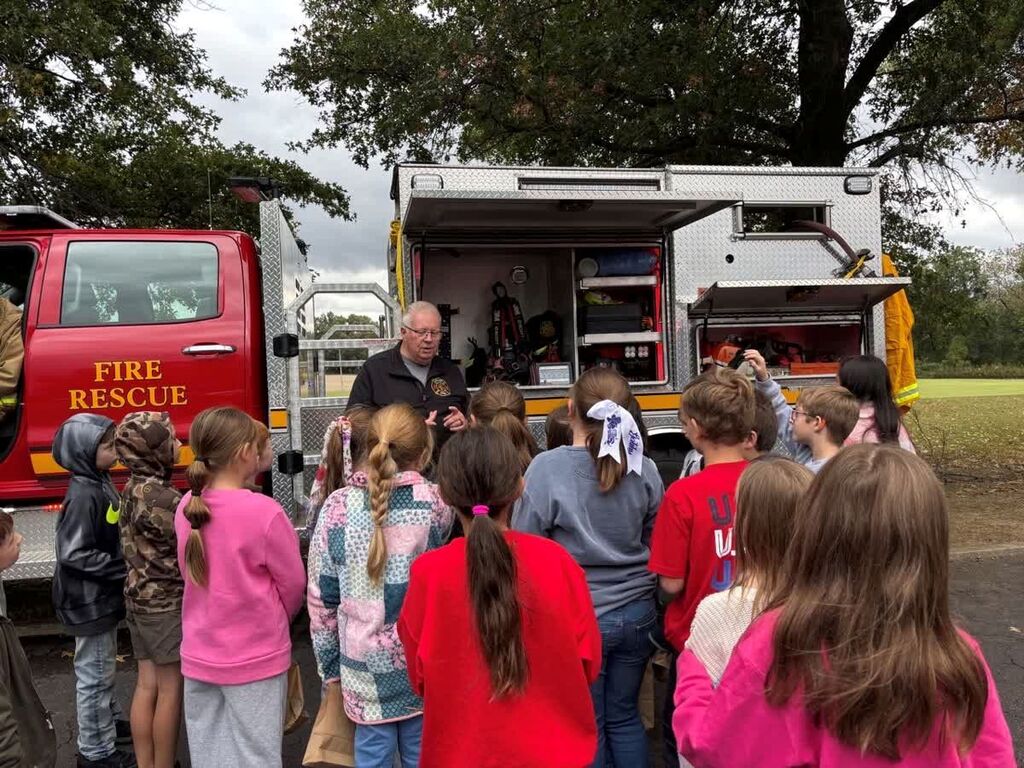 A group of Hillcrest students gather and listen to a firefighter at Careers on Wheels.