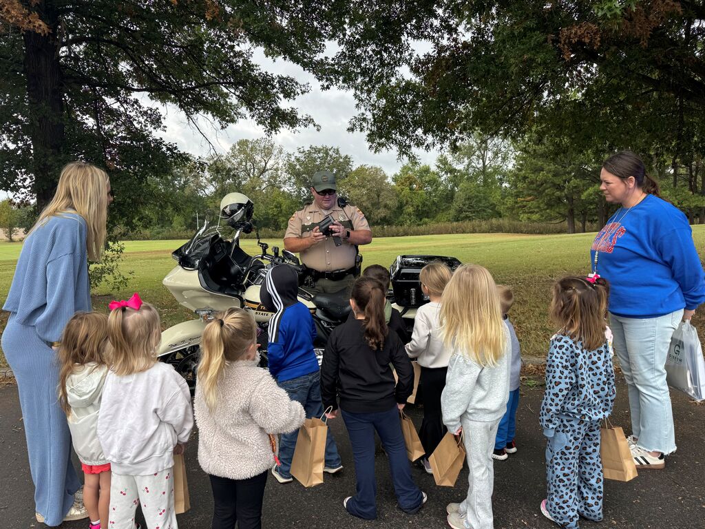 A group of Hillcrest students gather and listen to a Tennessee Highway Patrol officer at Careers on Wheels.