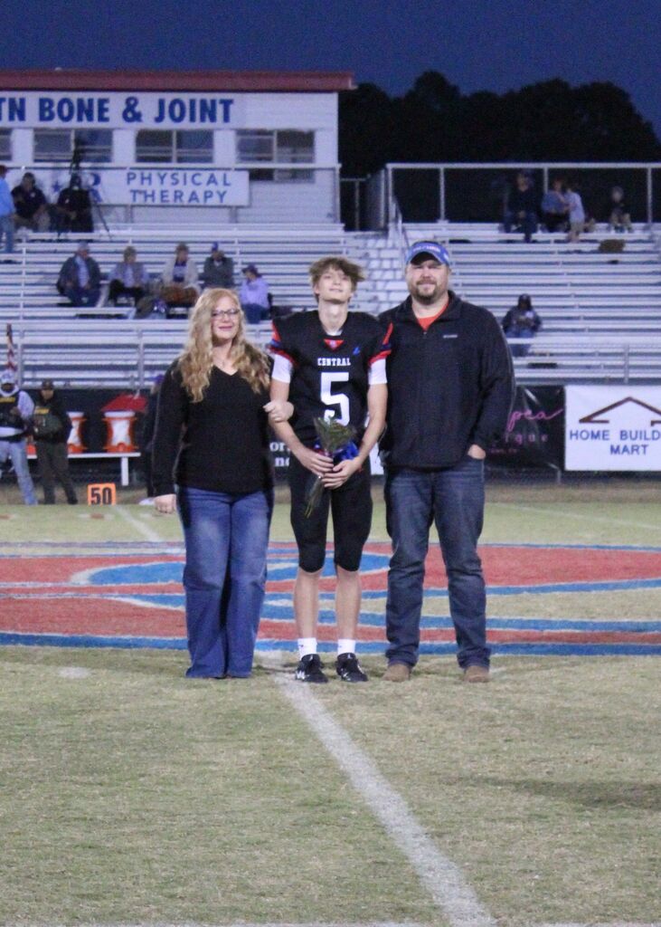 OCCHS Football senior and family smile for the camera.