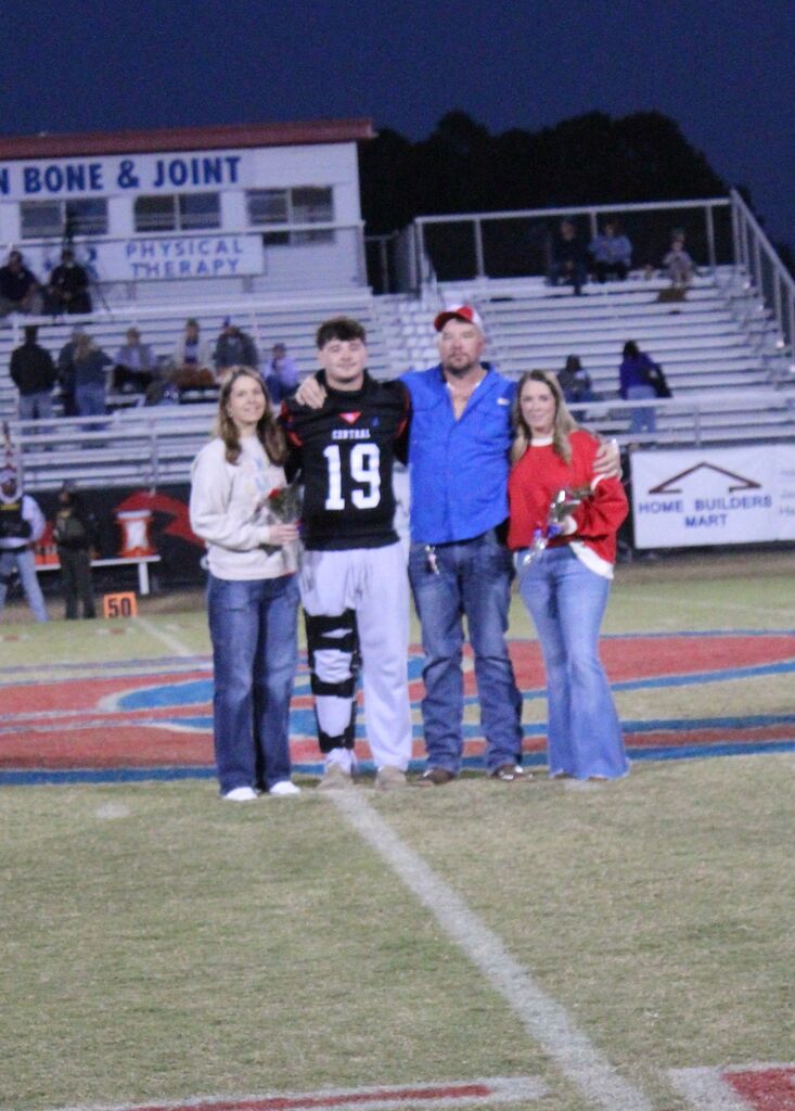 OCCHS Football senior and family smile for the camera.