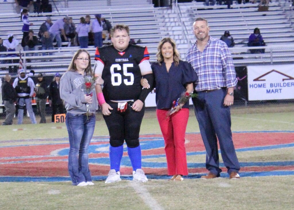 OCCHS Football senior and family smile for the camera.