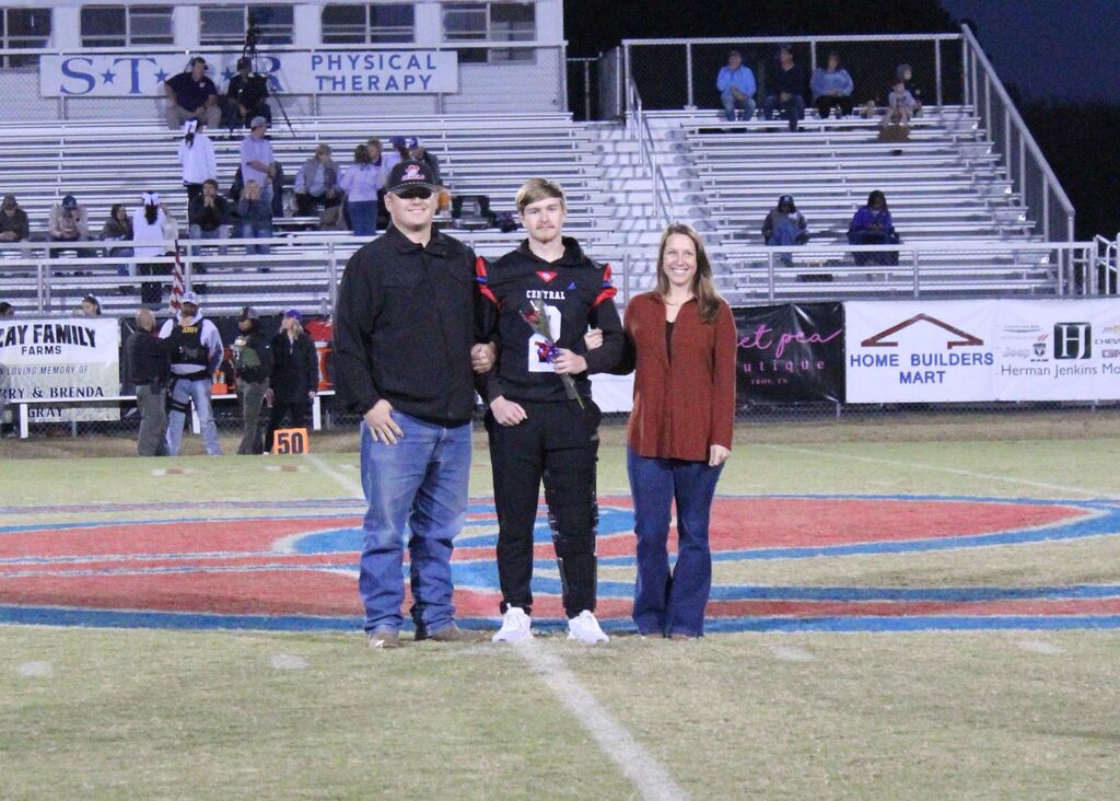 OCCHS Football senior and family smile for the camera.