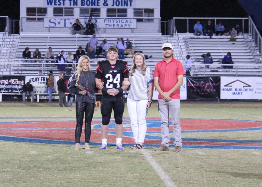 OCCHS Football senior and family smile for the camera.