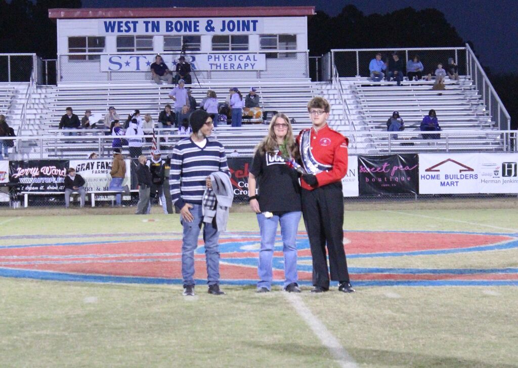 OCCHS Band senior and parents smile for the camera.