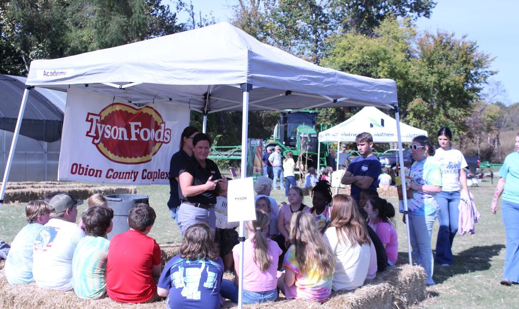 A presenter explains about the life cycle of a chicken while students listen closely.