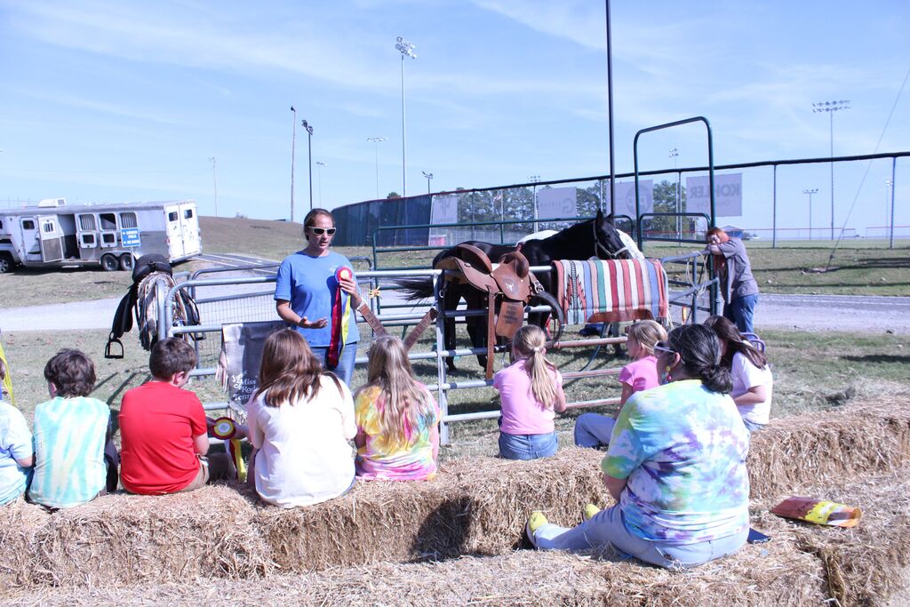 A presenter tells about horses to a group of students.