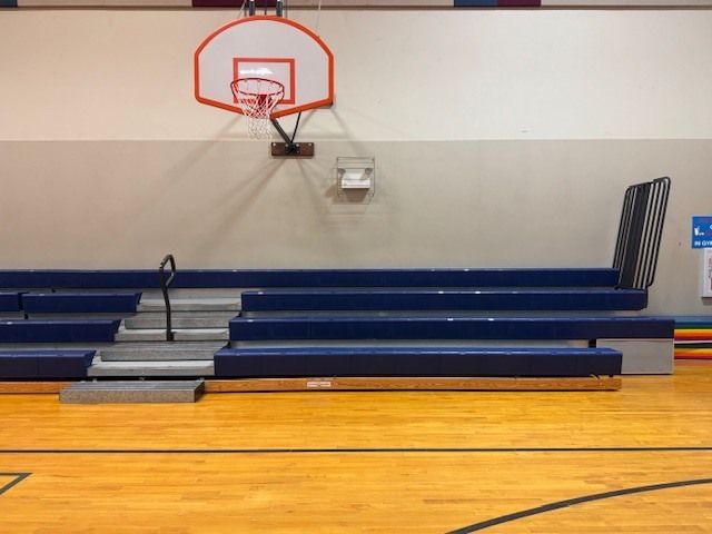 gym bleachers under a basketball hoop