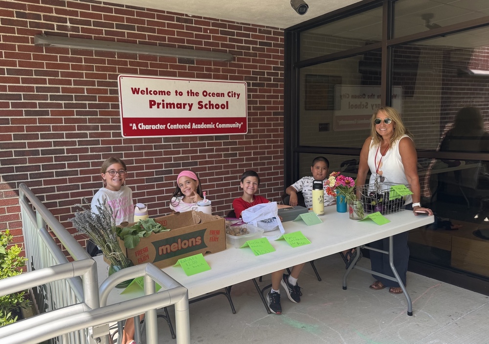 OCPS Primary School Students sell produce in the front of the building 